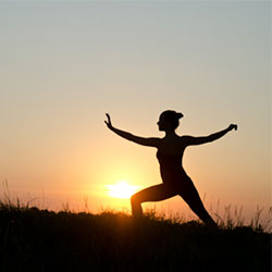 woman doing yoga pose at sunrise