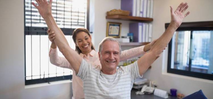 smiling-female-pta-and-male-patient-with-arms-raised