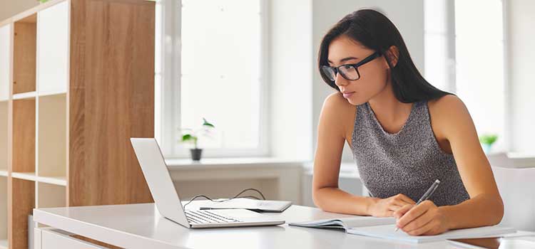 woman researching school programs on laptop