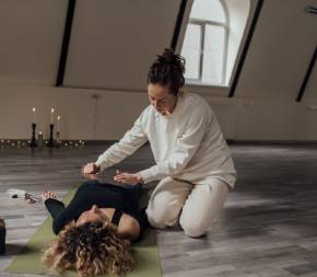 a spiritual healer with her hands over the chest of a client laying on the floor