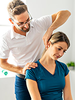 physical therapist adjusting woman's neck